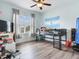 Bright bedroom with a gray bed frame, wood-look floors, a ceiling fan and natural light from the window at 5409 Fishhawk Ridge Dr, Lithia, FL 33547