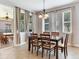 Charming dining room featuring a wooden table, chandelier, and natural light from large windows with modern blinds at 5409 Fishhawk Ridge Dr, Lithia, FL 33547