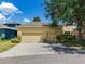 Detached two-car garage featuring lush landscaping, adjacent to a concrete driveway and neighborhood street at 5409 Fishhawk Ridge Dr, Lithia, FL 33547