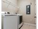 Bright laundry room with modern washer and dryer, tile floors and wire shelving at 5409 Fishhawk Ridge Dr, Lithia, FL 33547
