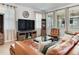Comfortable living room featuring a leather couch, entertainment center, and natural light from the window at 5409 Fishhawk Ridge Dr, Lithia, FL 33547