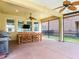 This covered patio features ceiling fans, outdoor dining, and a screened enclosure overlooking the backyard at 5409 Fishhawk Ridge Dr, Lithia, FL 33547