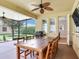 Screened in patio featuring a large wooden table and grill, with a view of the private yard at 5409 Fishhawk Ridge Dr, Lithia, FL 33547
