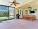 Spacious screened-in patio with a ceiling fan, a grill, and a backyard view at 5409 Fishhawk Ridge Dr, Lithia, FL 33547