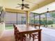 Screened in patio with a large wooden table, ceiling fans, and a view of the backyard at 5409 Fishhawk Ridge Dr, Lithia, FL 33547
