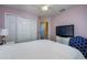 Relaxing bedroom with a white comforter, mounted TV, and large closet, all under a ceiling fan at 6216 Evansbrook Dr, Zephyrhills, FL 33541