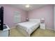 Cozy bedroom with a full bed, side tables, and bedside lamps under a window with blinds at 6216 Evansbrook Dr, Zephyrhills, FL 33541