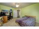 Comfortable bedroom featuring a patterned bedspread, desk space, and natural light from the window at 6216 Evansbrook Dr, Zephyrhills, FL 33541