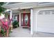 Close-up of the front door with sidelights, house number, and landscaping at 6216 Evansbrook Dr, Zephyrhills, FL 33541