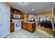 Well-lit kitchen with wood cabinets, white appliances, breakfast bar, and adjacent dining room at 6216 Evansbrook Dr, Zephyrhills, FL 33541