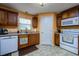 Bright kitchen featuring wood cabinets, white appliances, and tile floors at 6216 Evansbrook Dr, Zephyrhills, FL 33541