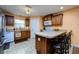 Functional kitchen featuring tile floors, breakfast bar, and white appliances at 6216 Evansbrook Dr, Zephyrhills, FL 33541