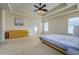 Large main bedroom with neutral carpet, tray ceiling, and access to a private patio at 6216 Evansbrook Dr, Zephyrhills, FL 33541