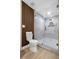 Stylish bathroom featuring a glass enclosed shower with gold fixtures, and modern toilet with wood slat wall at 6321 Balboa Ln, Apollo Beach, FL 33572