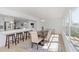 Bright dining room featuring a modern table, upholstered chairs, and adjacent kitchen island with bar seating at 6321 Balboa Ln, Apollo Beach, FL 33572