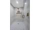 Modern shower featuring sleek white tiles, mosaic floor, gold fixtures, and a glass enclosure at 6321 Balboa Ln, Apollo Beach, FL 33572