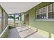 Enclosed patio shows plenty of natural light with green walls and tiled floor at 6402 Sawyer Rd, Tampa, FL 33634