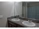 Bathroom featuring double sinks, a granite countertop and a large mirror at 6707 Blue Moon Way, Sun City Center, FL 33573