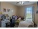 Cozy bedroom features a ceiling fan, large window, and charming decor at 6707 Blue Moon Way, Sun City Center, FL 33573