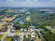 An aerial view shows the property nestled on a waterfront lot surrounded by lush greenery at 6908 11Th E Ave, Palmetto, FL 34221