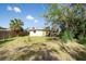 Backyard featuring green grass, scattered trees, and a wooden fence at 6908 11Th E Ave, Palmetto, FL 34221