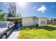 An exterior view of a one-story home showing the side, with a car port and a car in the driveway at 6908 11Th E Ave, Palmetto, FL 34221