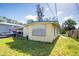 A view of the home exterior surrounded by an unkept lawn and overgrown vegetation at 6908 11Th E Ave, Palmetto, FL 34221