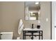 Modern bathroom with pedestal sink, wall mirror, dark hardware, toilet and a neatly folded white towel at 701 38Th N Ave, St Petersburg, FL 33704