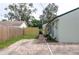 Extended brick driveway leads to the side door and backyard, with a new wooden fence on the adjacent property at 701 38Th N Ave, St Petersburg, FL 33704