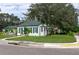 Corner lot home with a green roof, white siding, lush lawn, and mature landscaping showcasing its curb appeal at 701 38Th N Ave, St Petersburg, FL 33704