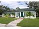 Inviting home with a green door and shutters, a brick walkway, and well-manicured lawn and landscaping at 701 38Th N Ave, St Petersburg, FL 33704