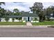 Charming single-story home with a green roof, shutters, landscaped yard, and welcoming brick pathway at 701 38Th N Ave, St Petersburg, FL 33704