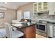 Open-concept kitchen featuring an island with barstool seating, stainless steel appliances, and marble backsplash at 701 38Th N Ave, St Petersburg, FL 33704