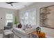 Cozy living room with white sofa, accent chair, and hardwood floors bathed in natural light from large windows at 701 38Th N Ave, St Petersburg, FL 33704