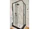 Corner shower stall with black trim and door hardware, white base and white/gray marble style tile surround at 701 38Th N Ave, St Petersburg, FL 33704