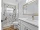 Modern bathroom featuring a white vanity with quartz counters and a walk-in shower with marble tile at 7509 S West Shore Blvd, Tampa, FL 33616