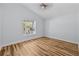 Bright bedroom with sleek hardwood floors, a ceiling fan, and a window offering natural light at 7509 S West Shore Blvd, Tampa, FL 33616