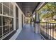 View of the home's welcoming front porch, featuring sturdy columns and railing details at 7509 S West Shore Blvd, Tampa, FL 33616