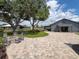 Spacious backyard with stone patio, fire pit, and several buildings; string lights add ambiance at 812 Jameson Rd, Lithia, FL 33547