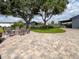 Beautiful backyard with stone patio, fire pit, and view of additional buildings, string lights, and open pastures at 812 Jameson Rd, Lithia, FL 33547