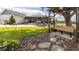 Gorgeous backyard includes a patio with seating, bench, lush lawn, and mature trees at 812 Jameson Rd, Lithia, FL 33547