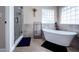 Serene bathroom featuring a standalone tub, glass block window, and a modern shower with tiled walls and glass door at 812 Jameson Rd, Lithia, FL 33547