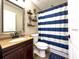 Bright bathroom with modern fixtures, and a blue and white striped shower curtain at 812 Jameson Rd, Lithia, FL 33547