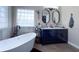 Bright bathroom features a freestanding tub, dual sinks with modern fixtures and natural light from a glass block window at 812 Jameson Rd, Lithia, FL 33547