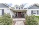 Charming front porch with rocking chairs, potted plants, and decorative details at 812 Jameson Rd, Lithia, FL 33547