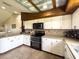 Bright kitchen featuring stainless appliances, white cabinets, and a unique corrugated metal ceiling with wooden beams at 812 Jameson Rd, Lithia, FL 33547