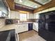 Bright kitchen featuring stainless appliances, white cabinets, and a unique corrugated metal ceiling with wooden beams at 812 Jameson Rd, Lithia, FL 33547