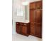 Bathroom showcasing wooden vanity with storage, a mirror, and neutral tile flooring at 8338 Old Town Dr, Tampa, FL 33647