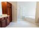 Well-lit bathroom features wooden cabinetry, a walk-in shower, and a soaking tub for ultimate relaxation at 8338 Old Town Dr, Tampa, FL 33647