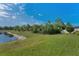 Picture of spacious backyard with grass leading to a pond in a natural setting at 8717 Emeraldwood Way, Land O Lakes, FL 34637